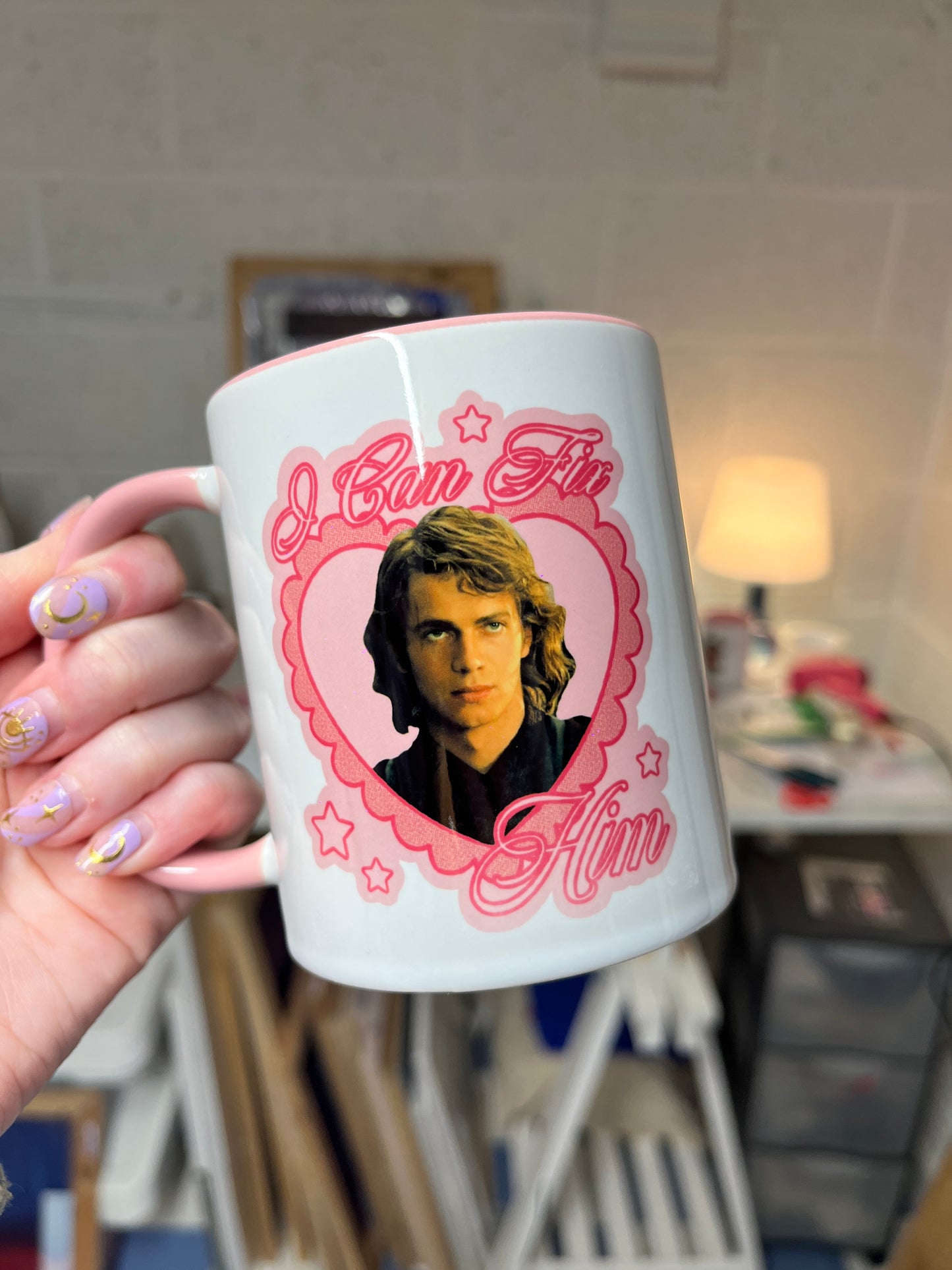 A ceramic mug with a design featuring Anakin Skywalker and the phrase 'I can fix him' held in a person's hand.