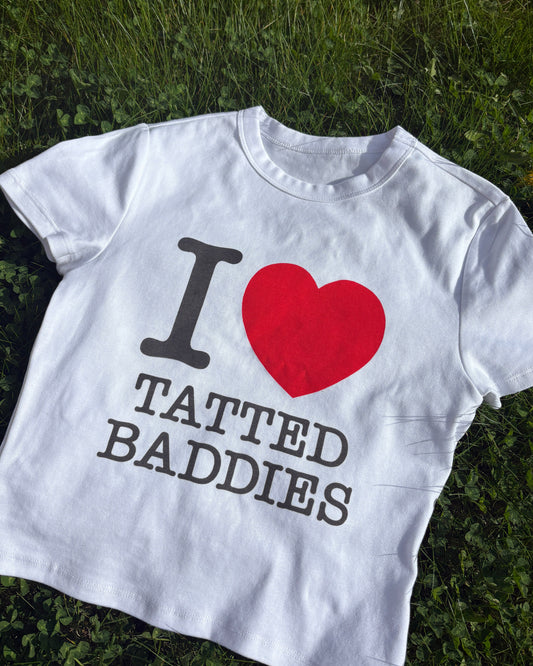 White tank top with 'I ❤️ Tatted Baddies' text on grass